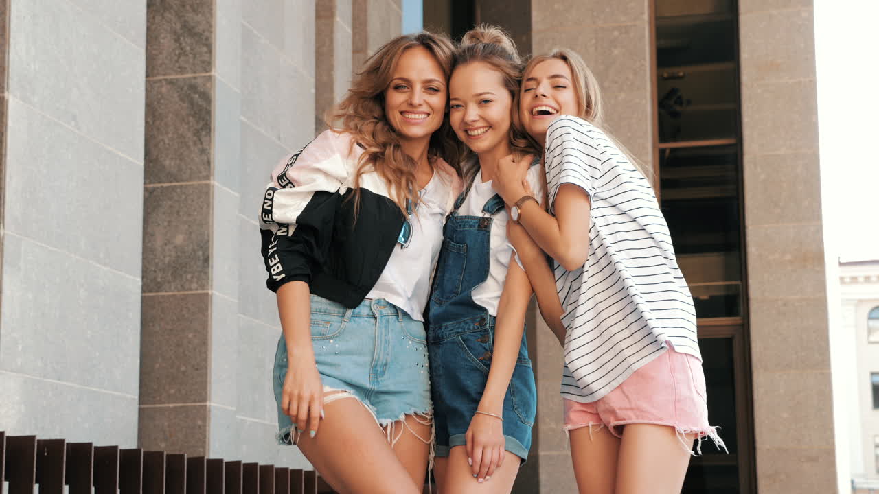 세 명의 젊은 여성들이 야외에서 포즈를 취하고 있습니다.