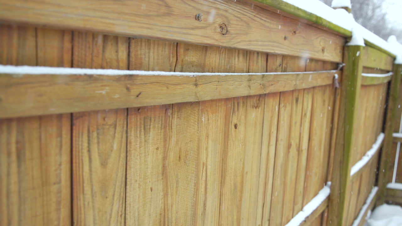 nieve cayendo contra la valla en cámara lenta - ancho