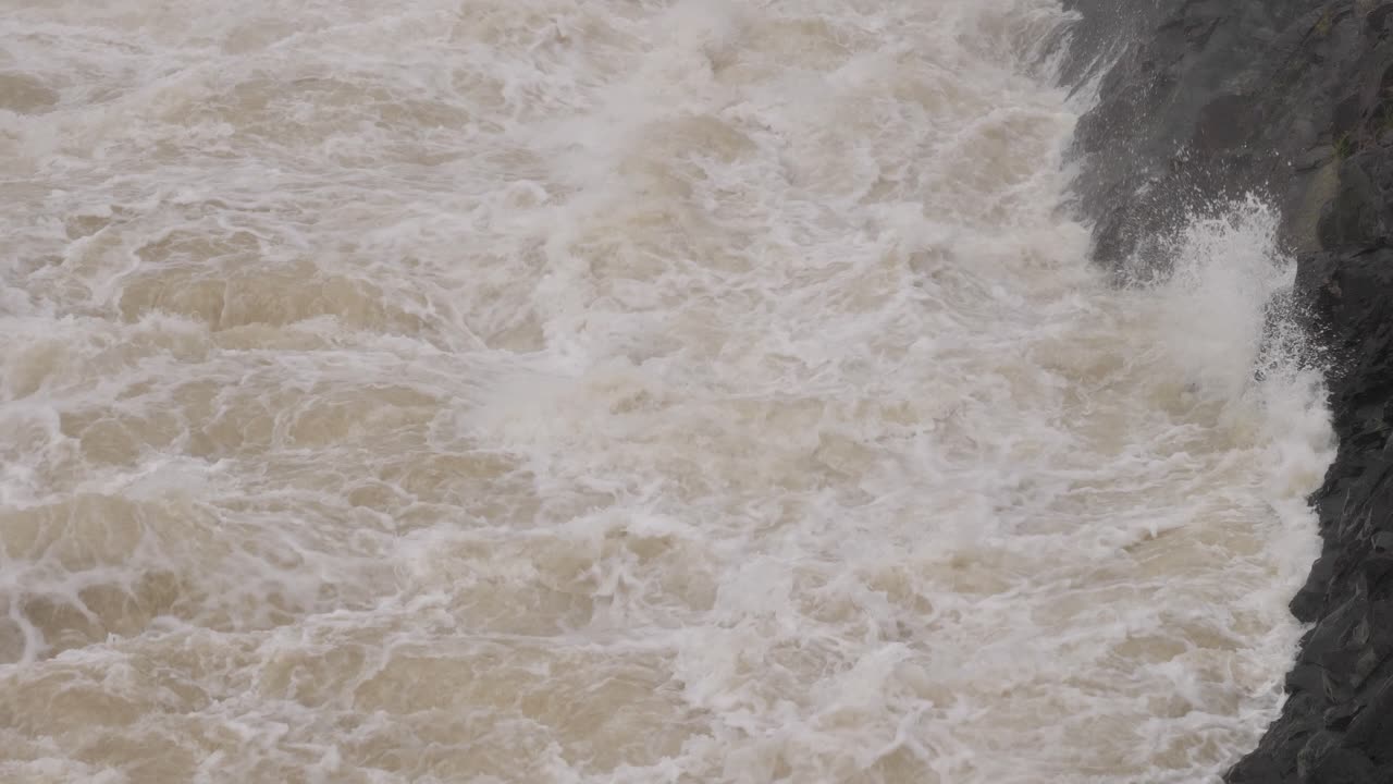 Handheld shot of turbulent waterflow from Hinze Dam under heavy rain and water flows during La Ni&ntilde;a, Gold Coast Hinterland, Queensland, Australia