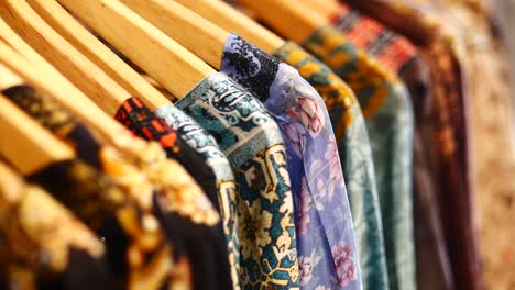 colorful printed clothes hanging on wooden hangers