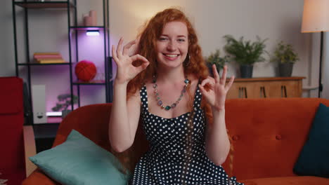 Happy-cheerful-redhead-woman-looking-approvingly-at-camera-showing-ok-gesture,-positive-like-sign