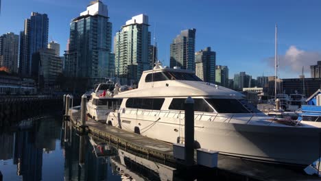 Luxusyachten-Vertäut-An-Einem-Zugefrorenen-Steg-Mit-Der-Skyline-Von-Vancouver-Im-Hintergrund-Und-Spiegelbild-Im-Ruhigen-Wasser