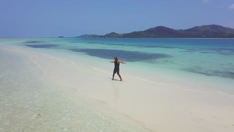 Drohne-Fidschi-Korallenriff-Mann-Geht-Weiße-Sandbank-Malalo-Insel-Aqua-Tiefblau-Malerische-Landschaft-Sonnig-Schön-Entspannend-Nadi-Luftaufnahme-Filmisch-Kreisend-Nach-Links-Bewegung