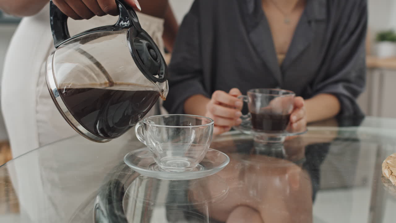 Woman Pouring Coffee into Glass Cup