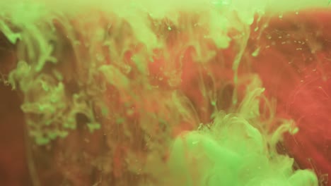 Video-of-close-up-of-green-and-red-ink-in-water-with-copy-space