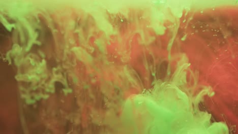 video of close up of green and red ink in water with copy space