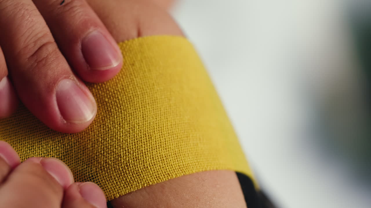 Kinesiology medical taping, doctor Physical therapist applying elastic surgical tape to patient body, treating injured knee young athlete.Post traumatic rehabilitation, sport physical therapy recovery