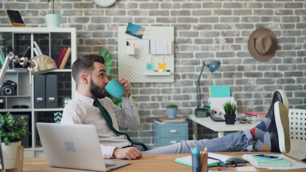 Uomo che si rilassa in ufficio con un caffè