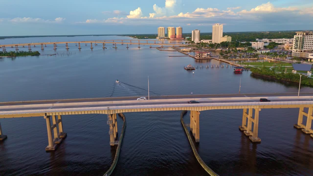 Cars driving on bridge to Fort Myers, Florida, aerial sideways, river panorama