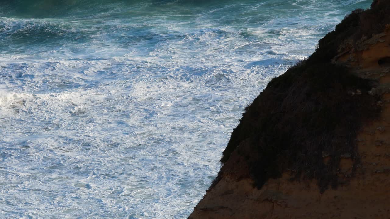 las olas del océano golpean los acantilados a lo largo de la gran carretera del océano