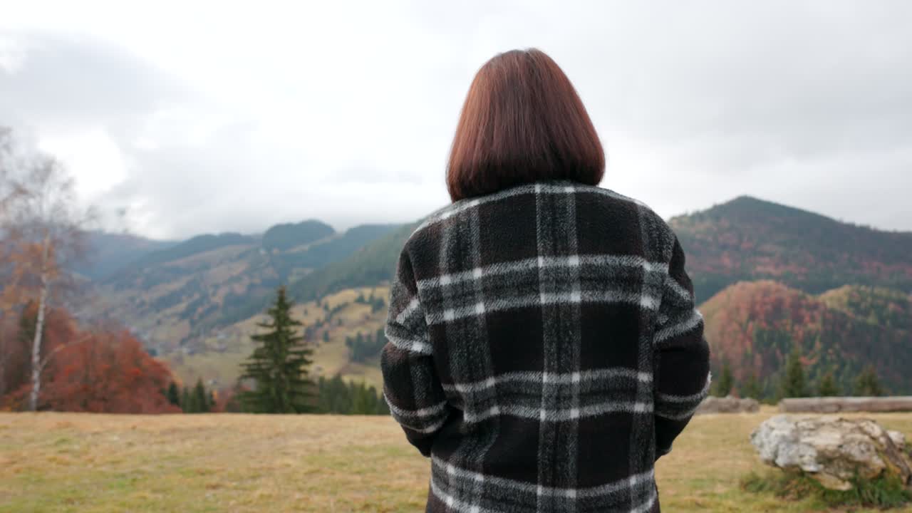 Amfiteatrul Transilvania, Moieciu de Sus, Brașov County, Romania - A Woman Walks Toward the Autumn-colored Mountains - Tracking Shot