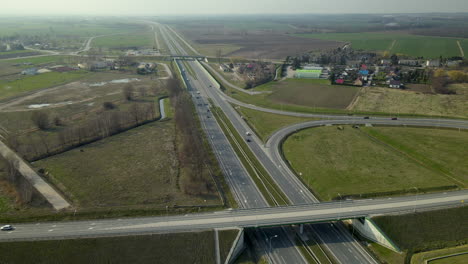 aerial view of highway road s7 cdry road and infinity road interchange revealing small village near the road in poland