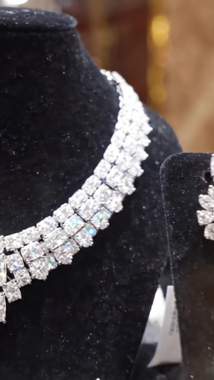 Squisita Esposizione di Gioielli Brillanti: Splendida Collana e Set di Orecchini Mostrati in Modo Accattivante in una Lussuosa Vetrina, Evidenziando l'Eleganza e l'Artigianalità Coinvolte