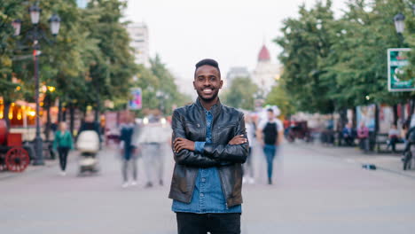 man in leather jacket smiling in a city street
