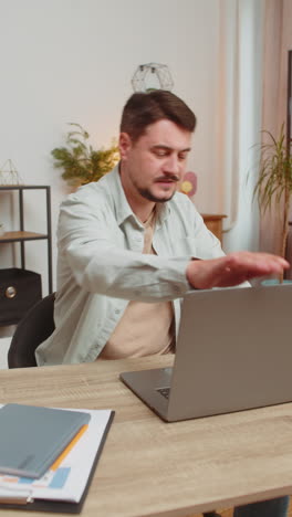 angry furious man freelancer using laptop working at home office having nervous breakdown at work