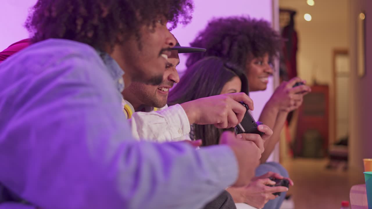 Amici che giocano ai videogiochi con illuminazione viola