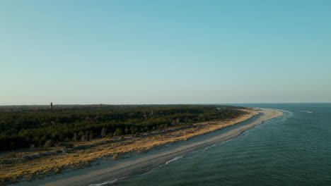 Faro-Distante-Sobre-Una-Exuberante-Vegetación-En-La-Playa-De-La-Península-De-Hel-En-El-Mar-Báltico,-Polonia