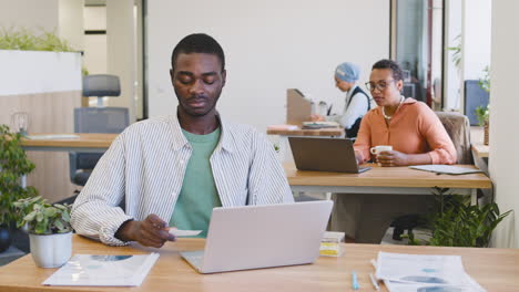 young worker working with laptop sitting at his desk