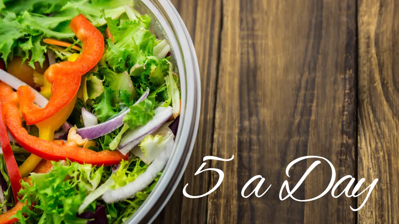 animación de 5 un día un día texto en blanco, sobre un cuenco de ensalada fresca en tablas de madera