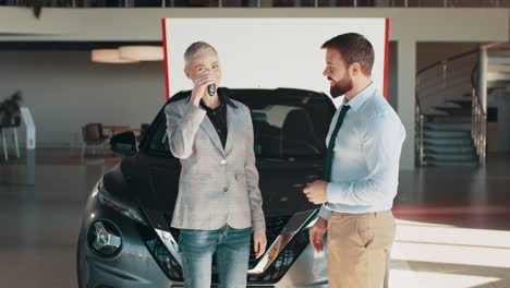 un cliente feliz recibiendo las llaves del coche en un concesionario