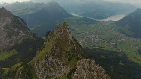 Speedramping-drone-shot-over-a-mountain-ridge-revaling-a-valley-and-lake-in-Switzerland