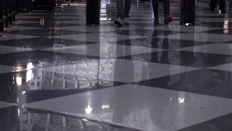 vista de ángulo bajo de piernas y pies en multitudes caminando por una terminal de aeropuerto el 26 de diciembre, uno de los días de vuelo más concurridos