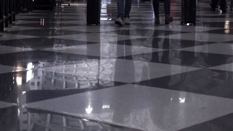 low angle view of legs and feet in crowds walking down an airport terminal on dec 26th, one of the busiest flight days