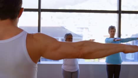 entrenador ayudando a las mujeres mayores en la realización de yoga 4k