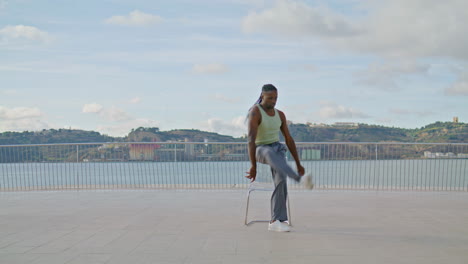 contemporary dancer practicing embankment vertically zoom on. man moving camera