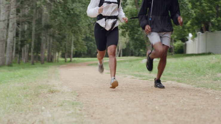 Couple Running Through a Forest Trail