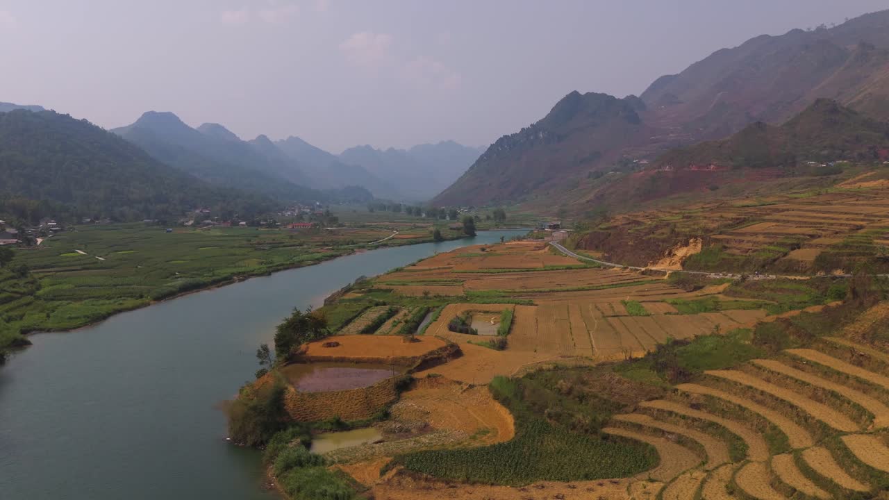 This serene drone footage reveals the natural beauty of Vietnam’s countryside, with vibrant green fields stretching into the distance, creating a stunning contrast with the flowing water below.