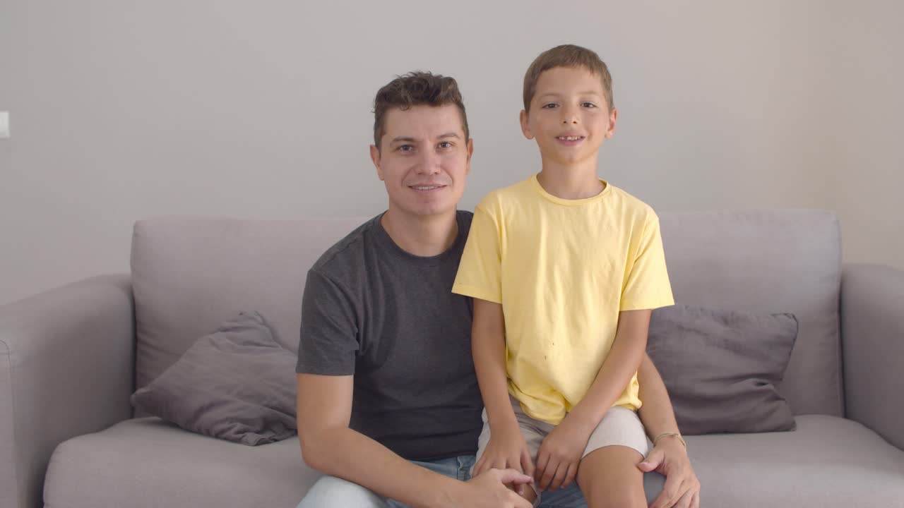 feliz apuesto padre soltero y hijo posando en casa