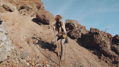 woman walking down steep scree in dystopian world