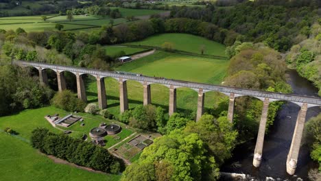 aerial view pontcysyllte aqueduct and river dee canal narrow boat bride in chirk welsh valley countryside rising pull back