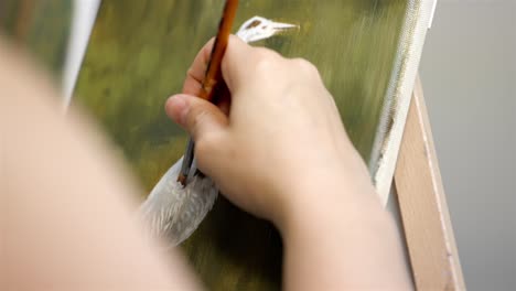 vista media de artistas pintando plumas blancas en el cisne en la pintura de jardín en aceite