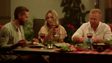 Friends-eating-meal-during-dinner.-Men-and-woman-talking-at-dining-table