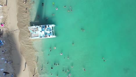 stunning 4k aerial overhead of families enjoying the sun, surf and sand as well as crystal blue waters at a luxury vacation resort on the beach