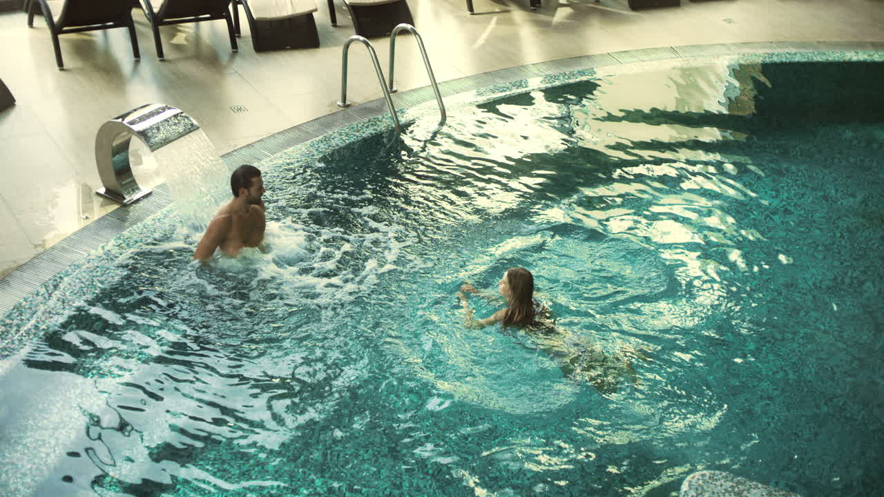 Glad par bader på luksus-spa. Afslappet familie hviler i boblebad.