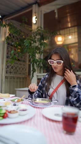 una mujer joven disfrutando de un desayuno turco.