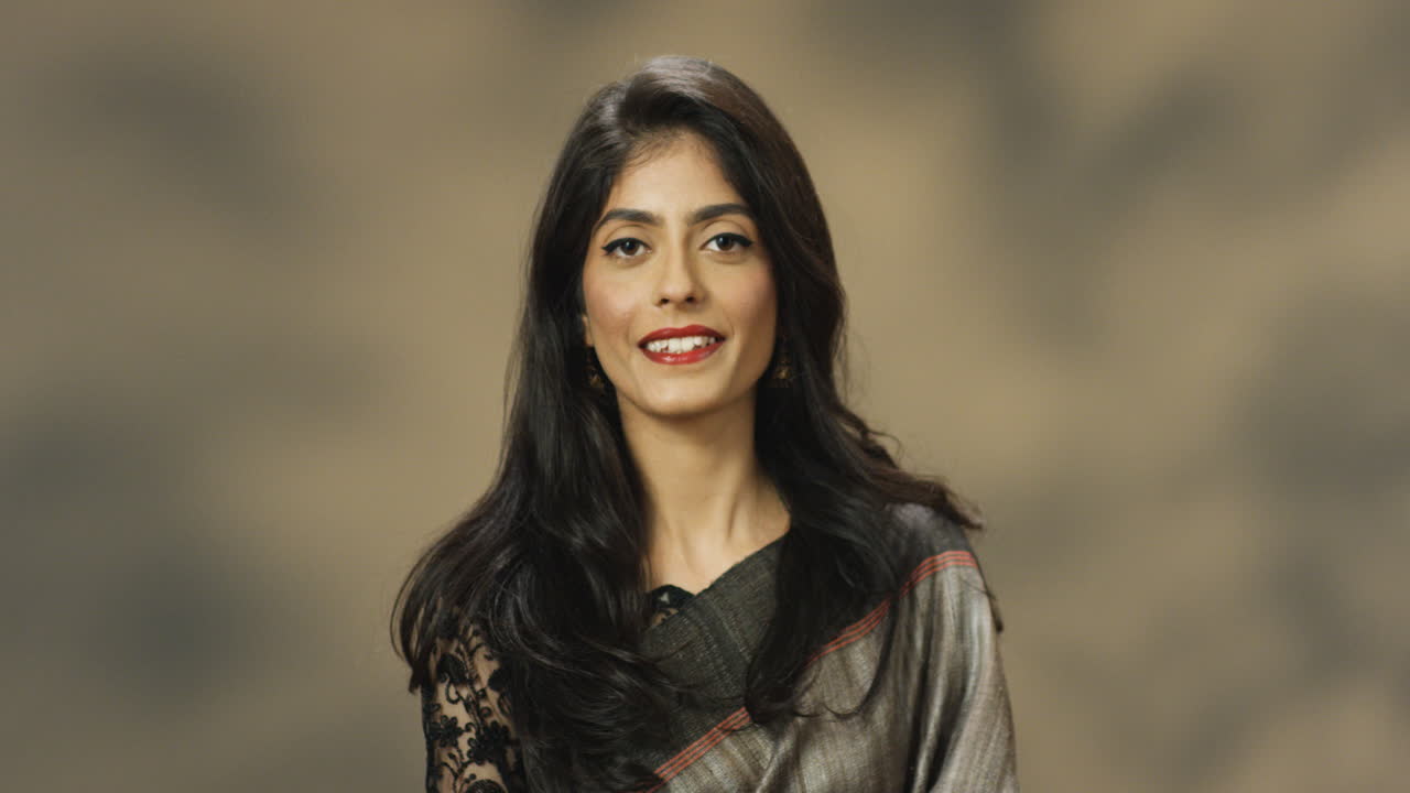 tiro de retrato de elegante mulher indiana em roupas tradicionais com cabelos longos, sorrindo para a câmera