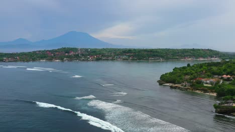 ocean-waves-crashing-with-view-of-two-Islands-Nusa-Ceningan-and-Lembongan,-aerial