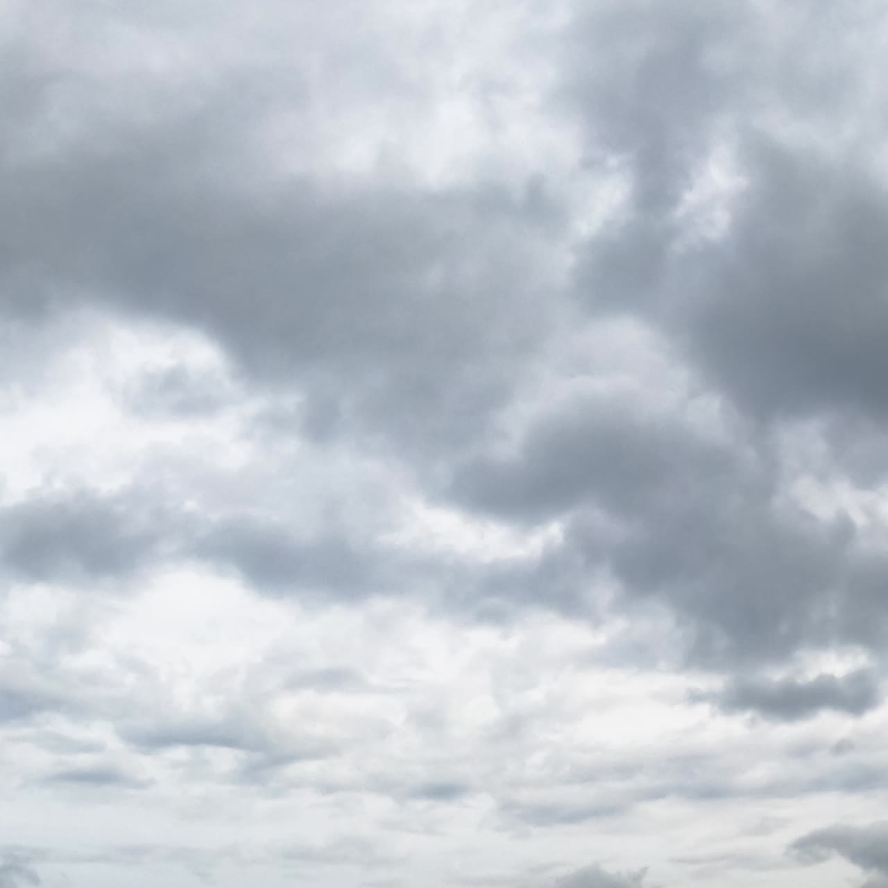 Grey rainy cloudscape in the sky. Dramatic clouds spreading in the atmosphere. Low angle view. Timelapse