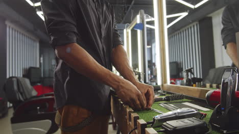 joven barbero negro preparando herramientas para el trabajo