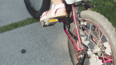 close-up of little girl spinning pedals of bicycle