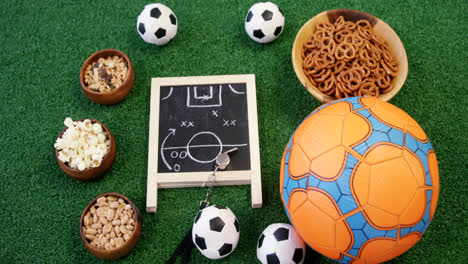 Schüssel-Mit-Snacks,-Fußball-Und-Schiefer-Auf-Kunstrasen-4k