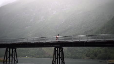 man performing backflip in slow motion off of a bridge in norway, europe