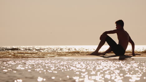 silhouette of a young man sitting on a small sand island