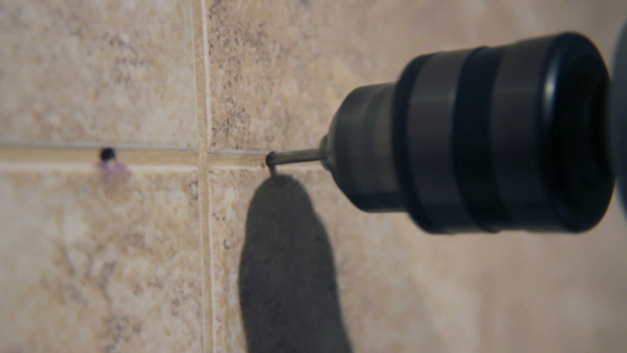 Close-up of a Drill Bit Making a Hole in a Tiled Wall