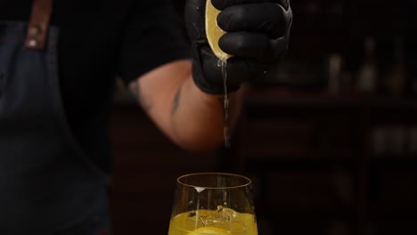 bartender squeezing lemon over drink