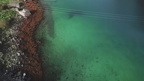 forward, fast tilt down drone shot over a road with rocky cliffs in the background